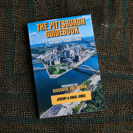 The Pittsburgh Guidebook by Discover The Burgh, photos of downtown Pittsburgh with gold lettering on book cover