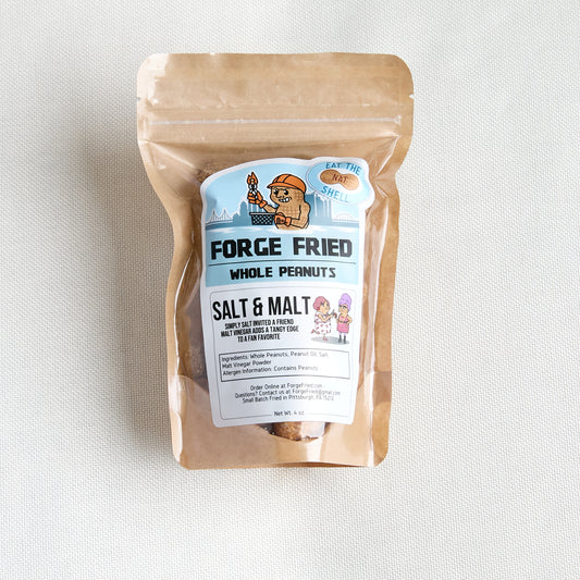 A kraft paper stand-up pouch of 'Forge Fried Whole Peanuts' in the 'Salt & Malt' flavor, featuring a cartoon nut mascot and product label, set against a neutral light gray textured background.