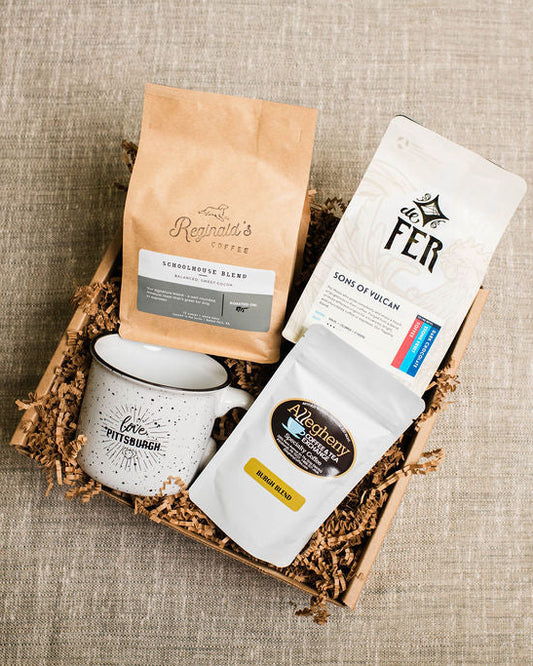 Coffee gift set with mug, coffee beans, and packaging on a textured surface