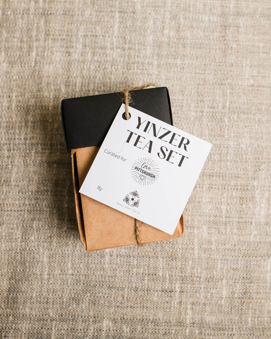 Tea set packaging with a tag on a textured fabric background