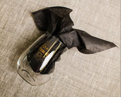 wine Glass with black tissue on a textured beige surface