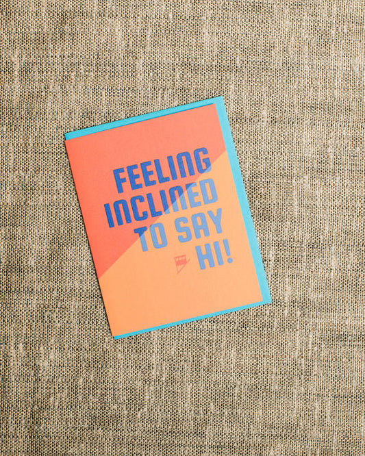 Card with 'Feeling inclined to say hi!' text on a textured beige background