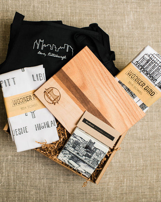 pittsburgh Gift box with wood cutting board, black apron, tea towels, and coasters