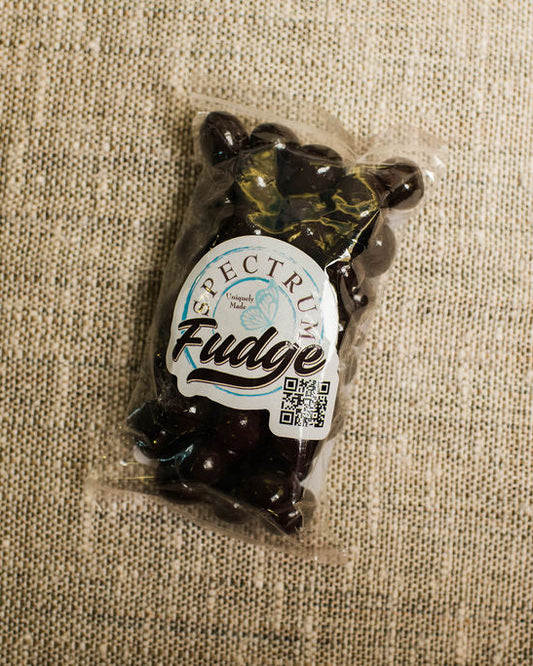 Packaged chocoloate covered espresso beans on a textured beige surface