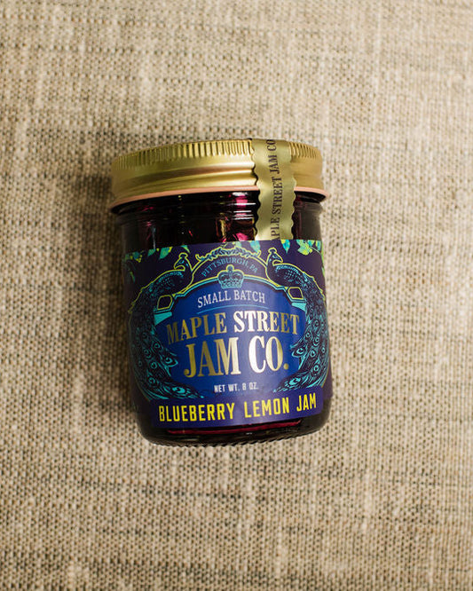 Jar of Maple Street Jam Co. Blueberry Lemon Jam on a textured beige surface