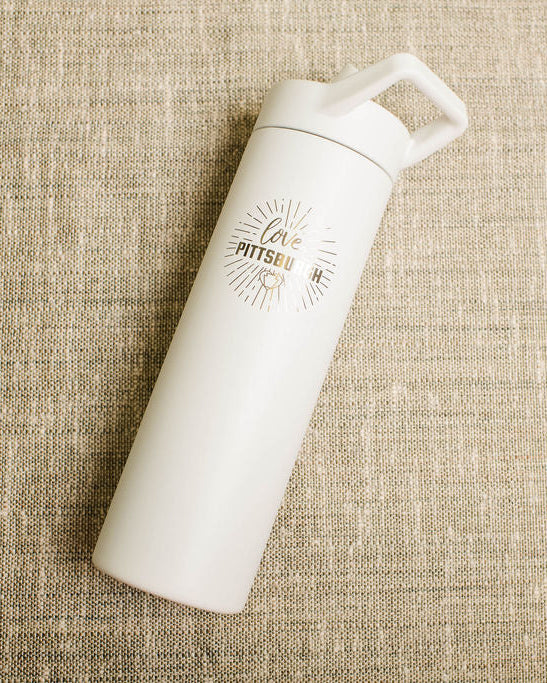 White water bottle with a love pittsburgh logo on a beige textured background