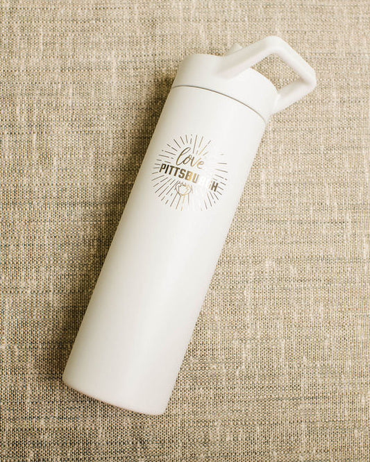 White water bottle with a love pittsburgh logo on a beige textured background