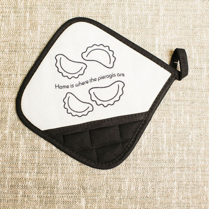 Potholder with pierogi design and text on a beige fabric background