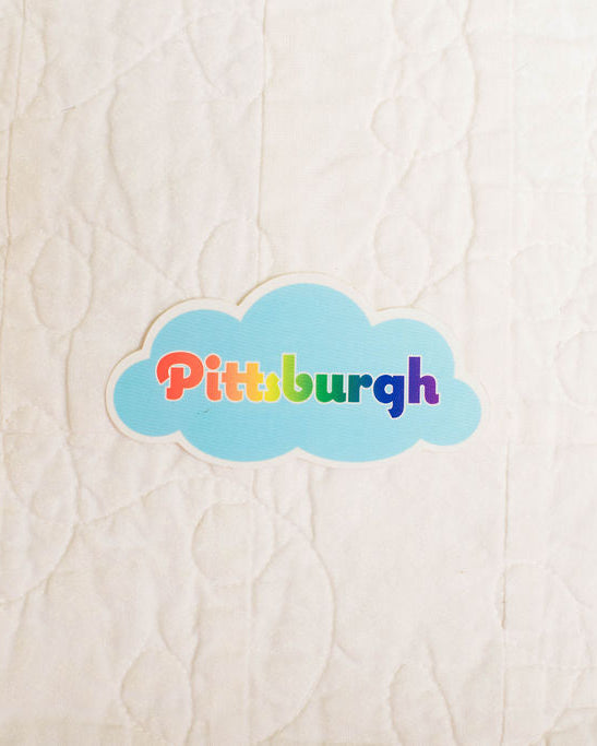 Colorful 'Pittsburgh' cloud sticker on a textured beige background