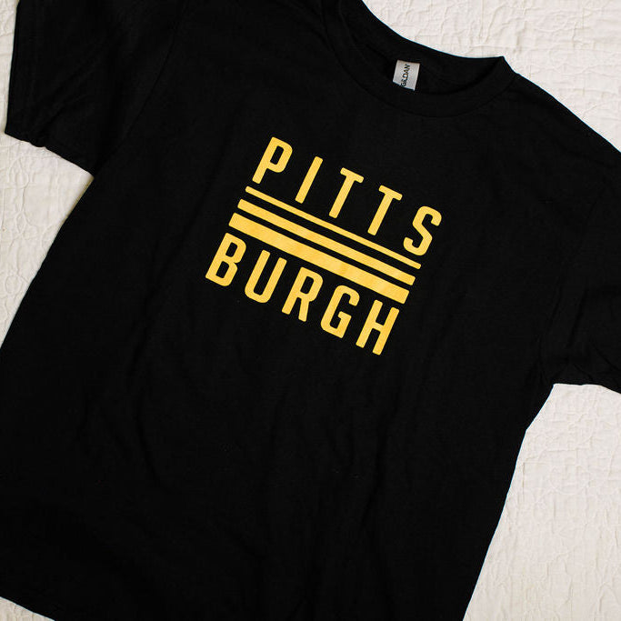 Black t-shirt with 'Pittsburgh' printed in yellow on a light background