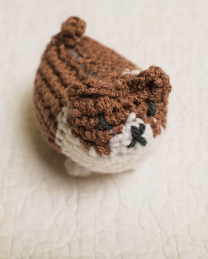 Crocheted corgi dog with brown and white pattern on a beige background