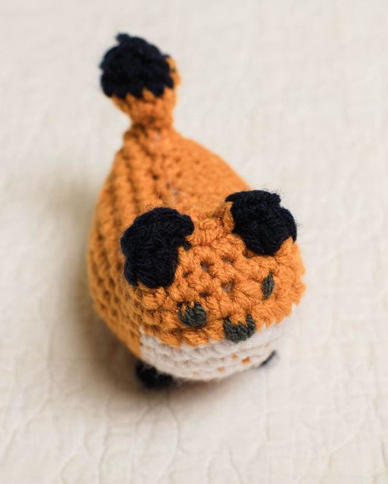 Crocheted fox toy on a white background