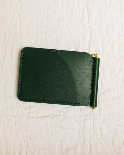 Green leather wallet on a textured beige surface