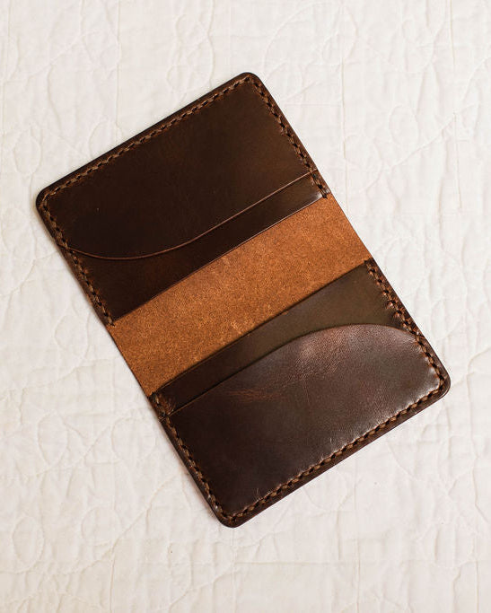 Brown leather cardholder on a light textured surface