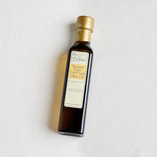 Bottle of olive oil with a gold cap on a textured beige background